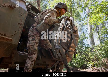 Il 29 agosto 2025 un fante del battaglione operativo della 13a brigata della Guardia nazionale Ucraina “Khartiia” pratica abilità aviotrasportate utilizzando un vettore americano M113 di personale corazzato, regione di Kharkiv, Ucraina. (Foto di Viacheslav Madiievskyi/Ukrinform) Foto Stock