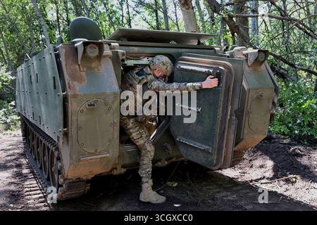 Un fante del battaglione operativo della 13a brigata della Guardia nazionale Ucraina “Khartiia” apre la porta di un vettore americano M113 di personale corazzato rintracciato durante l’esercitazione di addestramento aereo, regione di Charkiv, Ucraina, il 29 agosto 2025 (foto di Viacheslav Madiievskyi/Ukrinform) Foto Stock