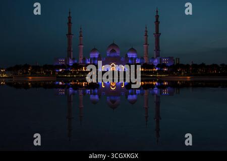 Emirati Arabi Uniti - Abu Dhabi - riflessioni notturne della grande Moschea dello Sceicco Zayed - minareti e portali brillanti ondulano tra le piscine di mezzanotte Foto Stock