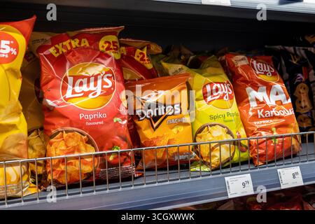 Le patatine Lay’s e Doritos sono confezionate su uno scaffale del supermercato, paprika e nacho con diversi gusti visualizzati di seguito, etichette dei prezzi, marchi di snack Foto Stock