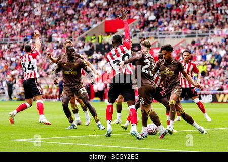 I giocatori del Sunderland fanno appello all'arbitro dopo che Michael Kayode di Brentford (secondo a sinistra) controlla la palla nell'area di rigore durante la partita di Premier League allo Stadium of Light di Sunderland. Data foto: Sabato 30 agosto 2025. Foto Stock