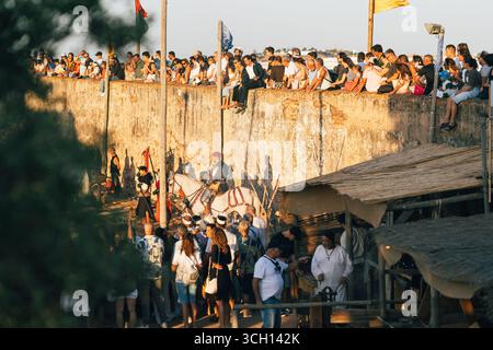 Castro Marim, Portogallo, 29 agosto 2025. Gli spettatori fiancheggiano le mura del castello mentre gli artisti vestiti da cavalieri intrattenono il pubblico sottostante. Foto Stock