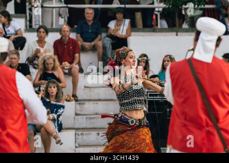 Castro Marim, Portogallo, 29 agosto 2025. La danza del ventre in costume tradizionale cattura il pubblico con una vivace performance durante il festival. Foto Stock