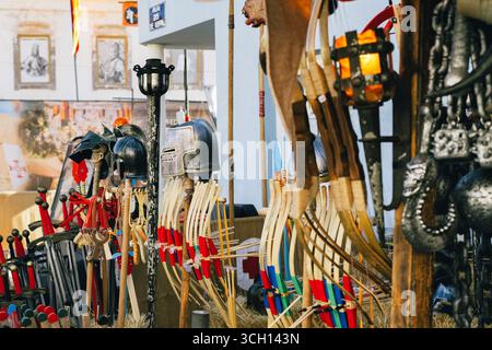 Castro Marim, Portogallo, 29 agosto 2025. Spade giocattolo, caschi, archi e mazze sono esposti in vendita in un mercato medievale di Castro Marim. Foto Stock