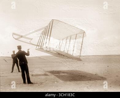Vista laterale del parapendio vola come un aquilone in prossimità del suolo, Wilbur a sinistra ed Orville a destra, glider rivolta in avanti a destra e ribaltato verso il basso. Foto Stock