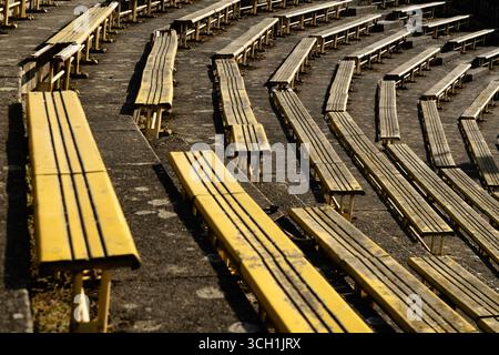 File di posti gialli allo stadio sportivo Strahov abbandonato e in rovina a Praga. Foto Stock