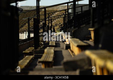 File di posti gialli allo stadio sportivo Strahov abbandonato e in rovina a Praga. Foto Stock