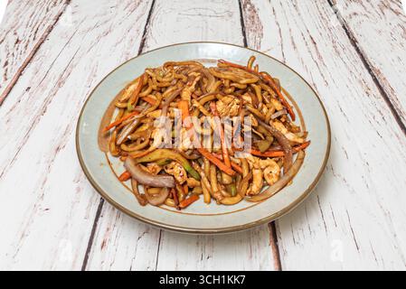 Cena romantica asiatica: Sottili tagliatelle saltate con capesante e asparagi, presentati su un piatto di porcellana con decorazioni floreali Foto Stock