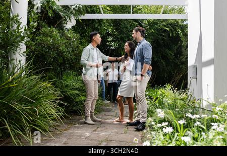 Amici che festeggiano all'aperto, condividono risate e gioia in giardino, piccoli matrimoni informali, a casa Foto Stock