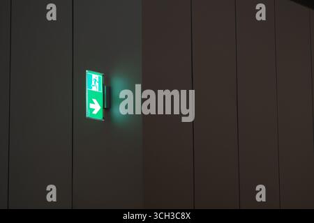 Segnale di uscita di emergenza illuminato in corridoio moderno Foto Stock