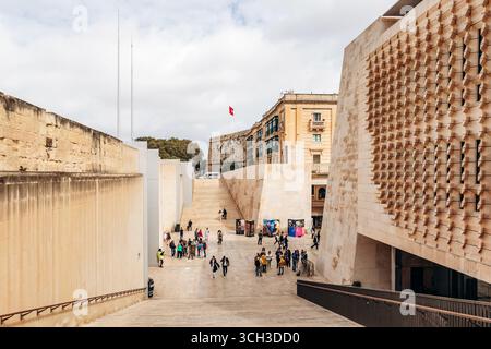 La Valletta, Malta - 10 aprile 2025: Ingresso alla capitale maltese con moderna architettura geometrica dell'edificio del Parlamento, bastioni di pietra calcarea, A. Foto Stock