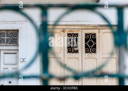 Porta ornata in legno maltese vista attraverso la griglia in ferro battuto a Floriana Foto Stock