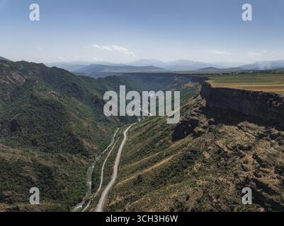 Veduta aerea del netto contrasto tra il terreno accidentato e la strada serpeggiante che attraversa la gola, Lori, provincia di Lori, Armenia. Foto Stock
