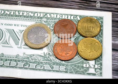 Monete e centesimi in euro, sfondo di monete di vari valori, 1 euro, 10 dieci e 2 due centesimi su banconota da 1 dollaro americano, Unione europea Foto Stock