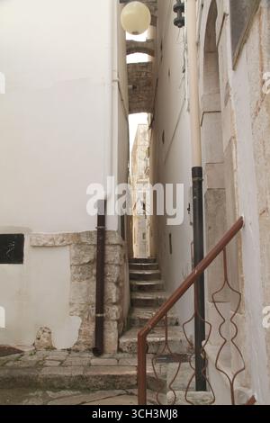 Vicoli stretti e scalini tra edifici nel centro storico di Putignano Foto Stock
