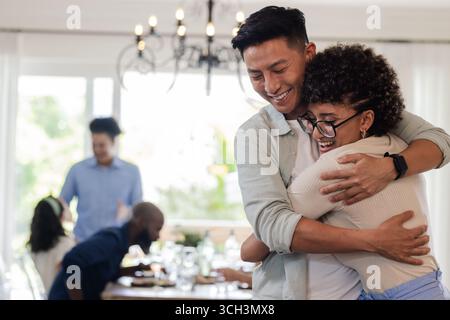 Celebrando l'amore e l'amicizia, gli ospiti si abbracciano al piccolo ricevimento di nozze informale, a casa Foto Stock