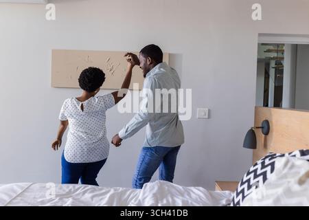 Balla gioiosamente a casa, coppia che condivide momenti divertenti insieme Foto Stock