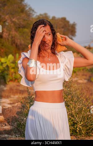 Elegante donna nella natura con capelli fluenti e abbigliamento estivo a Formentera, Isole Baleari, Spagna. Foto Stock