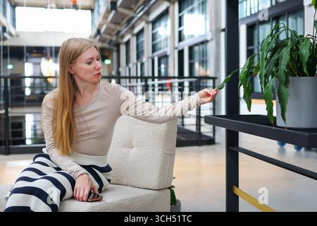 Ritratto di donna che riposa in un ufficio in stile loft, atmosfera tranquilla e luce naturale. Foto Stock