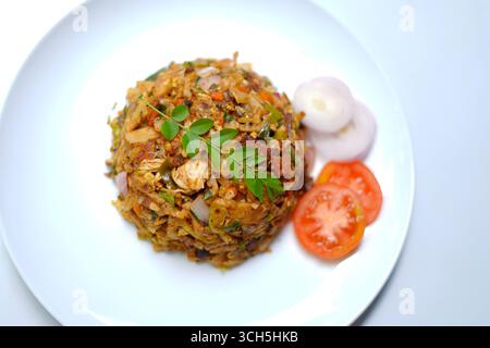Kottu Roti su piatto bianco con pomodori freschi e cipolle. fotografia di cibi piccanti asiatici. Foto Stock