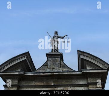Statua di Lady Justice che regge scale e spada sopra un ingresso al Castello di Dublino, un monumento storico e complesso governativo a Dublino, Irlanda. Foto Stock