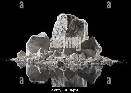 gesso su pietra su sfondo scuro. concetto di produzione, estrazione e uso del gesso, Foto Stock