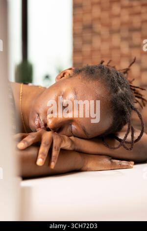 Primo piano di una donna esausta che riposa sulla scrivania con gli occhi chiusi e fa un breve pisolino durante l'orario di lavoro. Stanca imprenditrice in ufficio dorme pacificamente dopo aver raggiunto le scadenze dei progetti aziendali. Foto Stock