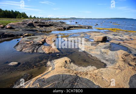 Costa rocciosa panoramica con acqua e pietre in una giornata di sole nel Mar bianco, Carelia russa, concetto di paesaggio settentrionale e natura Foto Stock