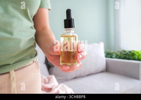 Una donna si strofina l'olio sulle mani. Idratare la pelle delle mani Foto Stock