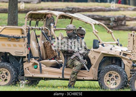 I soldati delle forze speciali della Bundeswehr cavalcano un buggy fuoristrada durante un'esercitazione tattica, dimostrando mobilità, lavoro di squadra e operazioni militari avanzate Foto Stock