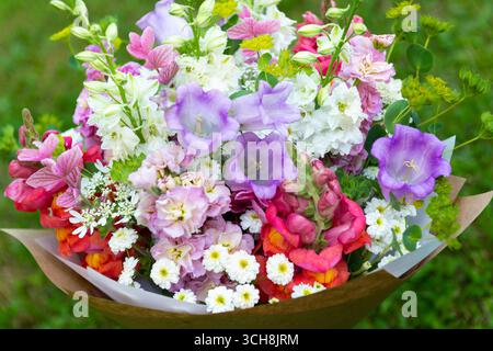 Bouquet di fiori avvolti di fiori primaverili misti. Splendida disposizione di fiori freschi color pastello. Bouquet di compleanno con draghi di dentini, matthiola Foto Stock