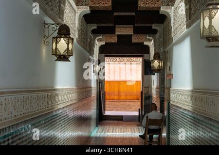 Corridoio d'ingresso della Madrasa Ben Youssef (Medersa Ben Youssef), Marrakech, Marocco, con piastrelle zellige, stucchi scolpiti e lanterne sospese. Foto Stock