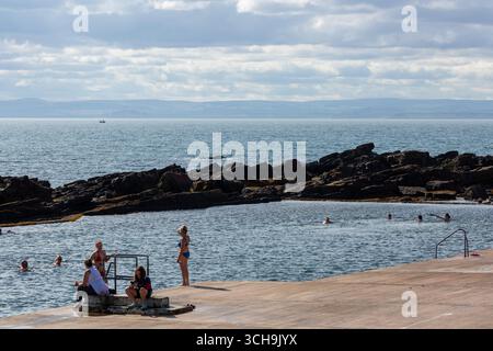 Persone che nuotano nella piscina di marea Cellardyke, Fife, Scozia Foto Stock