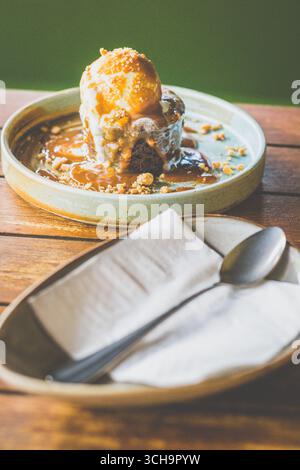 Budino di datteri di Toffee appiccicoso, salsa Butterscotch e gelato alla vaniglia Foto Stock
