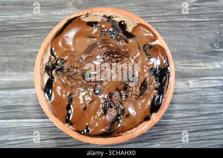 Panino cremoso con torta, ricoperto di pasta di cioccolato e ricoperto di torta, un piatto morbido preparato con strati di panna montata, biscotti, torta, Foto Stock