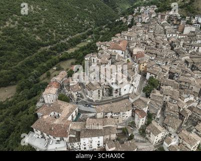 Veduta aerea di edifici molto affollati che scendono lungo la collina, una sinfonia di tetti in terracotta accostata alla verdeggiante valle, Scanno, Abruzzo, Italia. Foto Stock