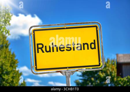 Baviera, Germania - 1 settembre 2025: FOTOMONTAGGIO, cartello giallo con l'iscrizione: Pensione, davanti al cielo azzurro e agli alberi verdi *** FOTOMONTAGE, Gelbes Schild mit der Aufschrift: Ruhestand, vor blauem Himmel und Grünen Bäumen Foto Stock