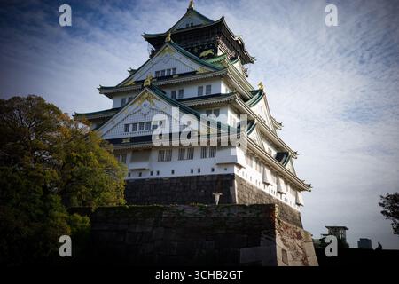 Vista ravvicinata del Castello di Osaka con dettagli decorati del tetto sotto il cielo limpido di Osaka, Giappone. Foto Stock