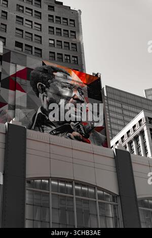 Murale di strada di un musicista che suona la chitarra dipinto su un muro di un edificio. Foto Stock