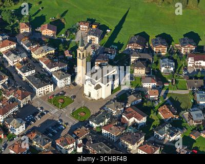 VISTA AEREA. Chiesa parrocchiale di San Luca Evangelista nella città di Padola nelle Dolomiti italiane. Provincia di Belluno, Veneto, Italia. Foto Stock