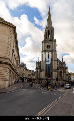 Vista sulla strada della chiesa di St Michaels su Walcot e ampia strada con un'alta guglia nella storica città di Bath, Inghilterra Foto Stock