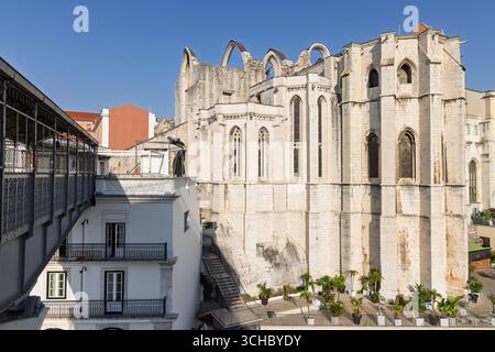 I resti scheletrici della chiesa del Carmo in stile gotico sono alti contro un cielo azzurro. Le rovine, danneggiate dal terremoto del 1755, sono un toccante h Foto Stock