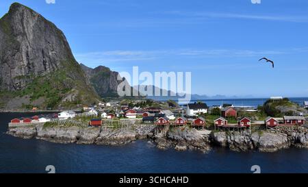 DAS Fischerdorf Hamnøy im Westen der Lofoten mit Blick auf die roten Fischerhäuser am Meer. Foto Stock