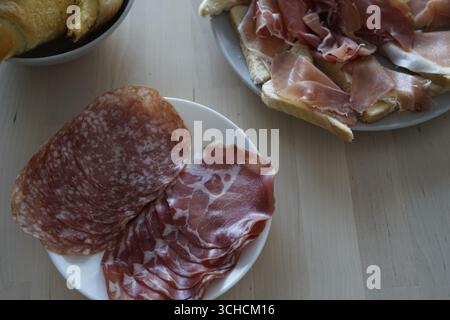 Un delizioso assortimento di salumi esposti ad arte su un tavolo di legno Foto Stock