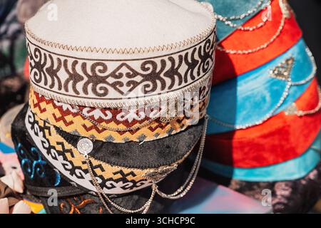 Sono esposti colorati cappelli kirghisi o kazaki con motivi tradizionali e catene d'argento, che celebrano il ricco patrimonio culturale dell'Asia centrale Foto Stock