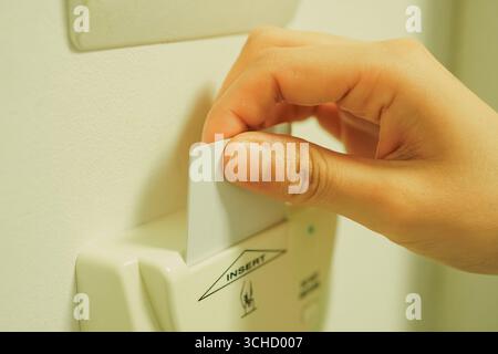 Mano di una donna che inserisce la chiave della carta dell'hotel Foto Stock