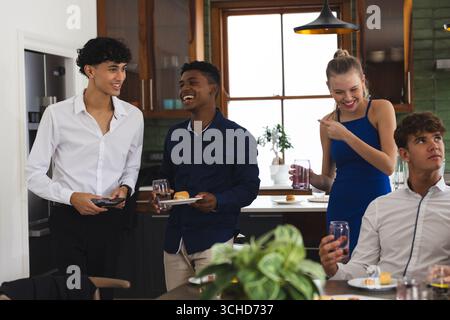 Gli adolescenti festeggiano a casa, ridono e gustando spuntini e bevande insieme. Festa, festa, amicizia, felicità, risate, divertimento Foto Stock