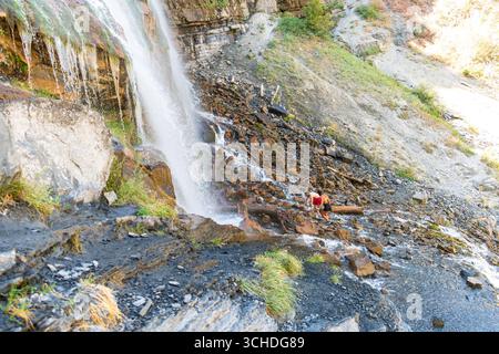 Provo, Utah, USA - 1 settembre 2025: I visitatori si riuniscono alla base delle Bridal Veil Falls mentre diversi ruscelli d'acqua cadono lungo la ripida parete rocciosa. Foto Stock