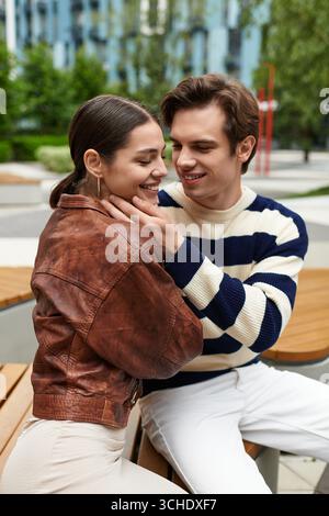 Un momento vivace tra una giovane coppia che si diverte in compagnia in un parco vivace. Foto Stock