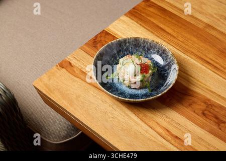 Un piatto gourmet splendidamente organizzato su un rustico tavolo in legno mette in mostra una deliziosa arte culinaria Foto Stock